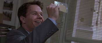 Movie still from “The Truth About Charlie” (2002), directed by Jonathan Demme – A man in a suit holding up a piece of paper; Close Up shot, Low angle