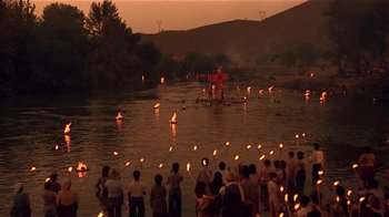 Movie still from “Time of the Gypsies” (1988), directed by Emir Kusturica – A group of people standing in the water holding torches; Extreme Wide shot, High angle