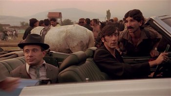 Movie still from “Time of the Gypsies” (1988), directed by Emir Kusturica – A group of men sitting next to each other in a car; Medium shot, Low angle