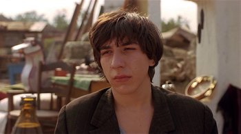 Movie still from “Time of the Gypsies” (1988), directed by Emir Kusturica – A young man with long hair wearing a jacket; Close Up shot, Low angle