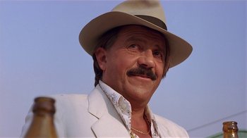 Movie still from “Time of the Gypsies” (1988), directed by Emir Kusturica – A person wearing a hat and a jacket; Close Up shot, Low angle