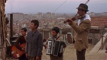 Movie still from “Time of the Gypsies” (1988), directed by Emir Kusturica – A group of young men standing on top of a hill; Wide shot, Low angle