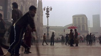 Movie still from “Time of the Gypsies” (1988), directed by Emir Kusturica – A group of people walking in the rain holding umbrellas; Extreme Wide shot, High angle