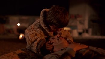 Movie still from “Time of the Gypsies” (1988), directed by Emir Kusturica – A young boy is playing with an older man's face; Close Up shot, Over the shoulder angle