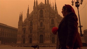Movie still from “Time of the Gypsies” (1988), directed by Emir Kusturica – An old woman standing in front of an old cathedral; Wide shot, Low angle