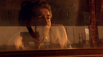 Movie still from “Time of the Gypsies” (1988), directed by Emir Kusturica – A man sitting in a car looking out the window; Close Up shot, High angle
