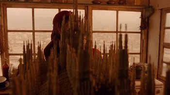 Movie still from “Time of the Gypsies” (1988), directed by Emir Kusturica – A man standing in front of a window with a view of a city; Close Up shot, Low angle