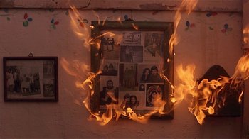 Movie still from “Time of the Gypsies” (1988), directed by Emir Kusturica – A picture frame is on fire with pictures on it; Extreme Close Up shot, High angle