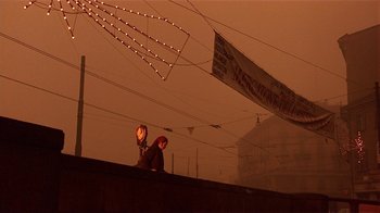 Movie still from “Time of the Gypsies” (1988), directed by Emir Kusturica – Two people standing on a bridge in the dark; Wide shot, Low angle