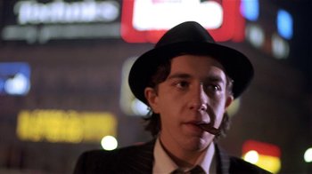 Movie still from “Time of the Gypsies” (1988), directed by Emir Kusturica – A man in a suit and hat smoking a cigar; Close Up shot, Low angle
