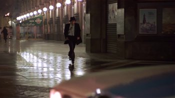 Movie still from “Time of the Gypsies” (1988), directed by Emir Kusturica – A man in a suit and hat walking down a street; Wide shot, Low angle