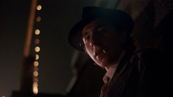 Movie still from “Time of the Gypsies” (1988), directed by Emir Kusturica – A man wearing a hat and smoking a cigarette; Close Up shot, Low angle