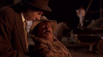 Movie still from “Time of the Gypsies” (1988), directed by Emir Kusturica – A man in a hat is talking to another man in a suit; Close Up shot, Over the shoulder angle