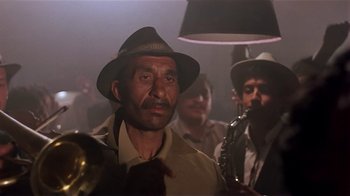 Movie still from “Time of the Gypsies” (1988), directed by Emir Kusturica – A group of men standing next to each other in a room; Close Up shot, Low angle