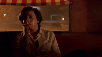 Movie still from “Time of the Gypsies” (1988), directed by Emir Kusturica – A man sitting in front of a window holding a wine glass; Close Up shot, Low angle