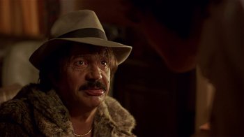 Movie still from “Time of the Gypsies” (1988), directed by Emir Kusturica – A person wearing a hat and a fur coat; Close Up shot, Over the shoulder angle