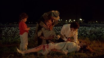 Movie still from “Time of the Gypsies” (1988), directed by Emir Kusturica – A group of people standing around a person on the ground; Medium shot, High angle