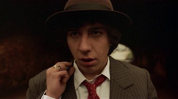 Movie still from “Time of the Gypsies” (1988), directed by Emir Kusturica – A young man in a suit and a tie; Close Up shot, Low angle