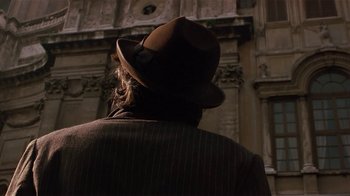 Movie still from “Time of the Gypsies” (1988), directed by Emir Kusturica – A man wearing a brown hat and a brown jacket; Close Up shot, Over the shoulder angle
