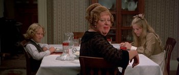 Movie still from “Tom Sawyer” (1973), directed by Don Taylor – An older woman sitting at a dinner table; Medium shot, High angle