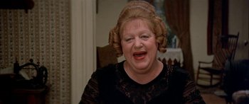 Movie still from “Tom Sawyer” (1973), directed by Don Taylor – An older woman wearing a black dress and a black wig; Close Up shot, High angle