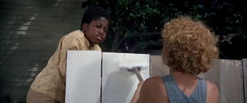 Movie still from “Tom Sawyer” (1973), directed by Don Taylor – A boy and a woman painting a wall; Medium shot, Over the shoulder angle