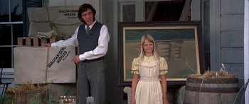 Movie still from “Tom Sawyer” (1973), directed by Don Taylor – A man and a young girl standing in front of a painting; Medium shot, Low angle