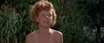Movie still from “Tom Sawyer” (1973), directed by Don Taylor – A young boy with curly red hair and blue eyes looking at the camera; Close Up shot, High angle