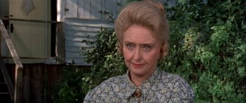 Movie still from “Tom Sawyer” (1973), directed by Don Taylor – An older woman in a floral shirt and a ponytail; Close Up shot, Over the shoulder angle