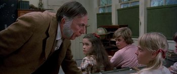 Movie still from “Tom Sawyer” (1973), directed by Don Taylor – An older man and two young children in a classroom; Close Up shot, Over the shoulder angle