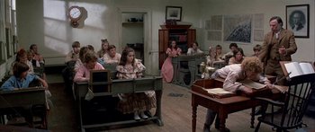 Movie still from “Tom Sawyer” (1973), directed by Don Taylor – A group of people sitting in a room with desks; Wide shot, High angle