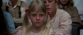 Movie still from “Tom Sawyer” (1973), directed by Don Taylor – A girl with pigtails is looking at the camera; Close Up shot, Low angle