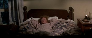 Movie still from “Tom Sawyer” (1973), directed by Don Taylor – A child laying in a bed with his arms stretched out; Medium shot, High angle