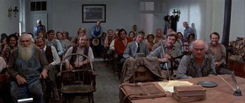 Movie still from “Tom Sawyer” (1973), directed by Don Taylor – A group of people sitting in chairs in a room; Wide shot, High angle