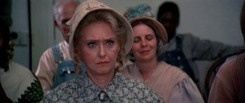 Movie still from “Tom Sawyer” (1973), directed by Don Taylor – Two women wearing hats and looking at the camera; Close Up shot, Over the shoulder angle