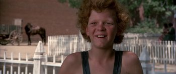 Movie still from “Tom Sawyer” (1973), directed by Don Taylor – A person with curly red hair smiling; Close Up shot, Low angle