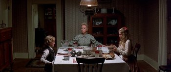 Movie still from “Tom Sawyer” (1973), directed by Don Taylor – A group of people sitting around a table eating food; Wide shot, High angle