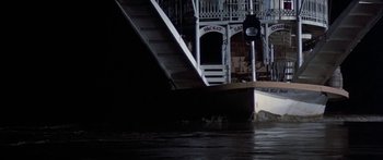 Movie still from “Tom Sawyer” (1973), directed by Don Taylor – A clock on the side of a building next to water; Extreme Wide shot, High angle