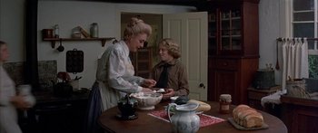 Movie still from “Tom Sawyer” (1973), directed by Don Taylor – A woman and a young boy are standing at a table; Medium shot, High angle