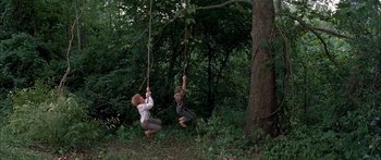 Movie still from “Tom Sawyer” (1973), directed by Don Taylor – Two people swinging on ropes in the woods; Wide shot, High angle