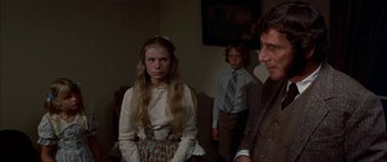 Movie still from “Tom Sawyer” (1973), directed by Don Taylor – A group of people standing in a living room together; Medium shot, Over the shoulder angle