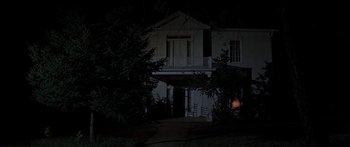 Movie still from “Tom Sawyer” (1973), directed by Don Taylor – A house that is lit up at night time; Extreme Wide shot, Low angle