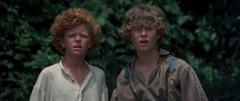 Movie still from “Tom Sawyer” (1973), directed by Don Taylor – Two young boys standing next to each other in front of a tree; Close Up shot, High angle