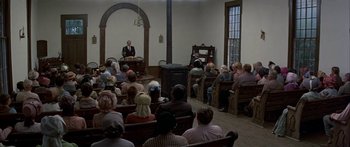 Movie still from “Tom Sawyer” (1973), directed by Don Taylor – A group of people sitting in a room with chairs; Wide shot, High angle