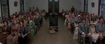 Movie still from “Tom Sawyer” (1973), directed by Don Taylor – A large group of people sitting in a room; Wide shot, High angle