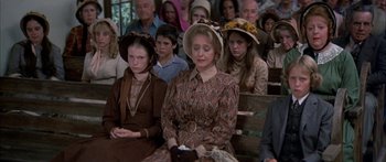 Movie still from “Tom Sawyer” (1973), directed by Don Taylor – A group of people sitting in a room; Medium shot, High angle