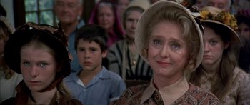 Movie still from “Tom Sawyer” (1973), directed by Don Taylor – An older woman in a hat is in front of an audience; Close Up shot, Over the shoulder angle