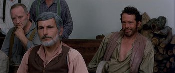 Movie still from “Tom Sawyer” (1973), directed by Don Taylor – A man sitting next to another man on a bench; Close Up shot, Over the shoulder angle