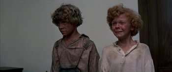 Movie still from “Tom Sawyer” (1973), directed by Don Taylor – Two young men standing next to each other in front of a white wall; Medium shot, Low angle