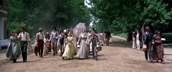 Movie still from “Tom Sawyer” (1973), directed by Don Taylor – A group of people walking down a dirt road; Wide shot, High angle